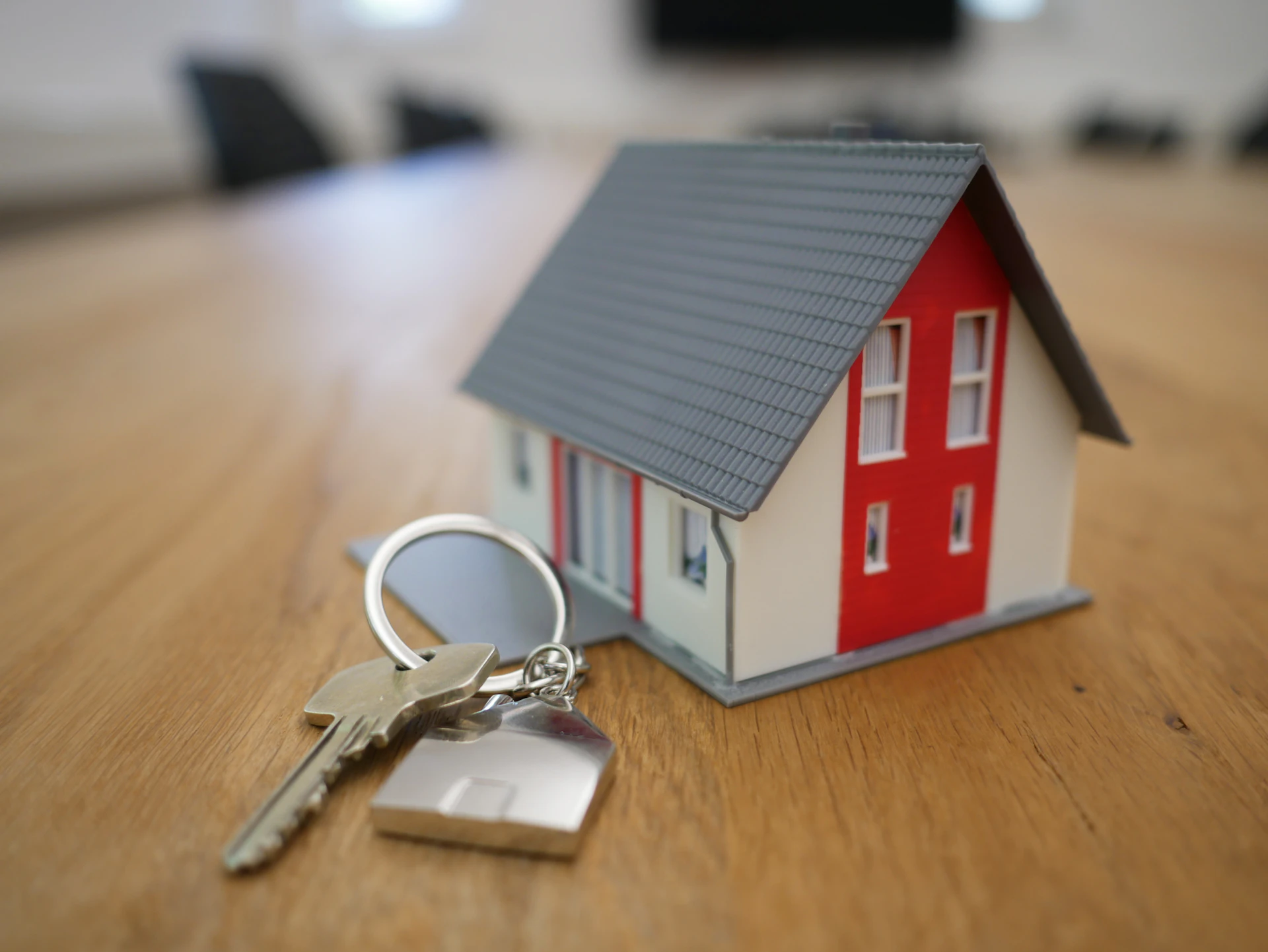 Model house and keys resting on a desk