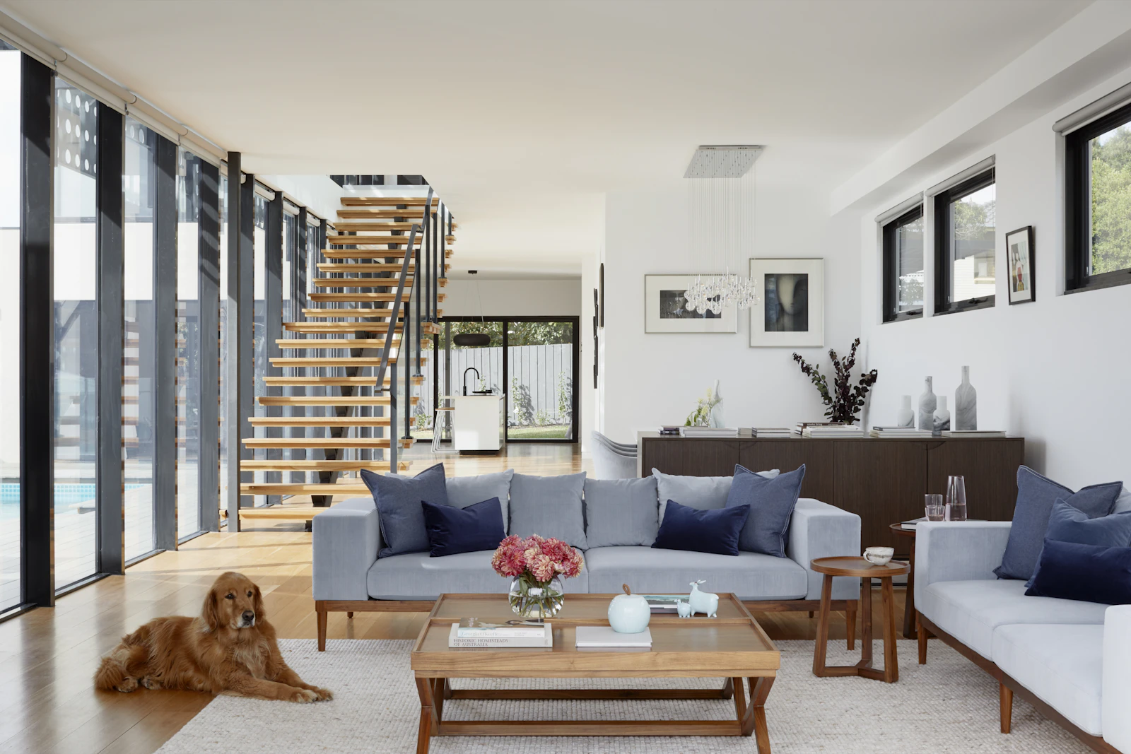 Living room with a floating staircase and full-height windows